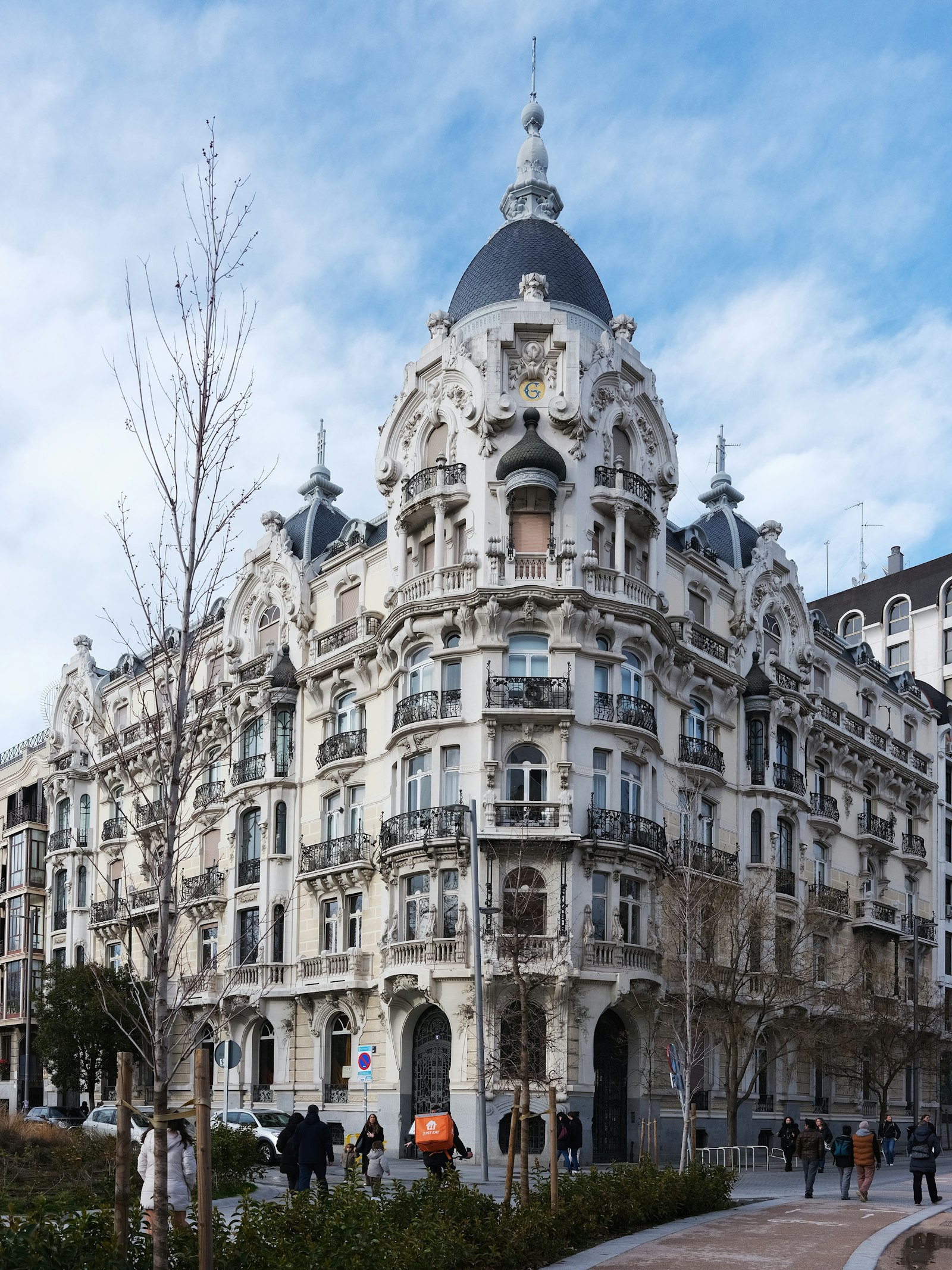 Edificio clásico de esquina en Madrid, con cúpula y balcones de hierro
