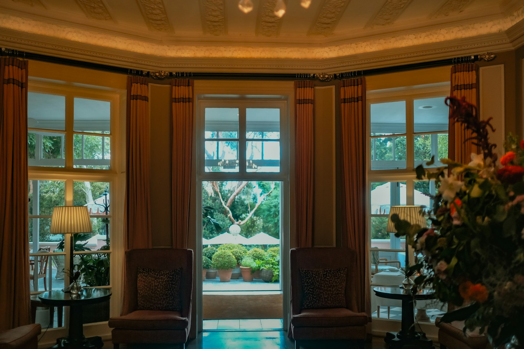 Salón clásico con cortinas y ventanales a un jardín